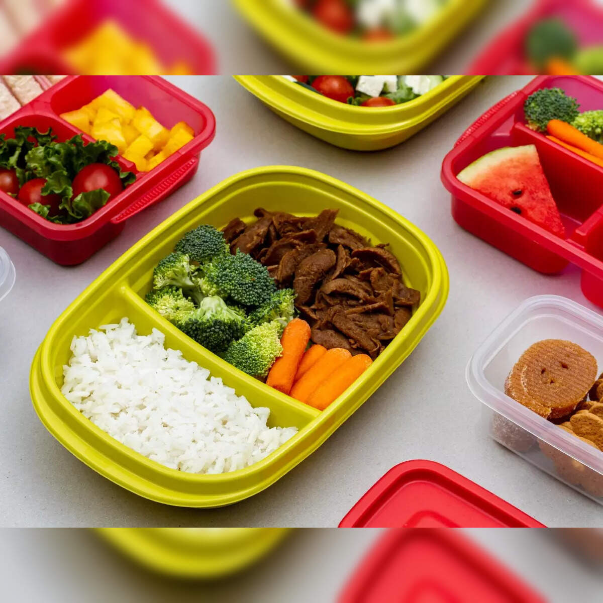 Colorful divided lunch boxes with healthy foods like rice, vegetables, fruits, and meat illustrate safe and balanced school meals for kids
